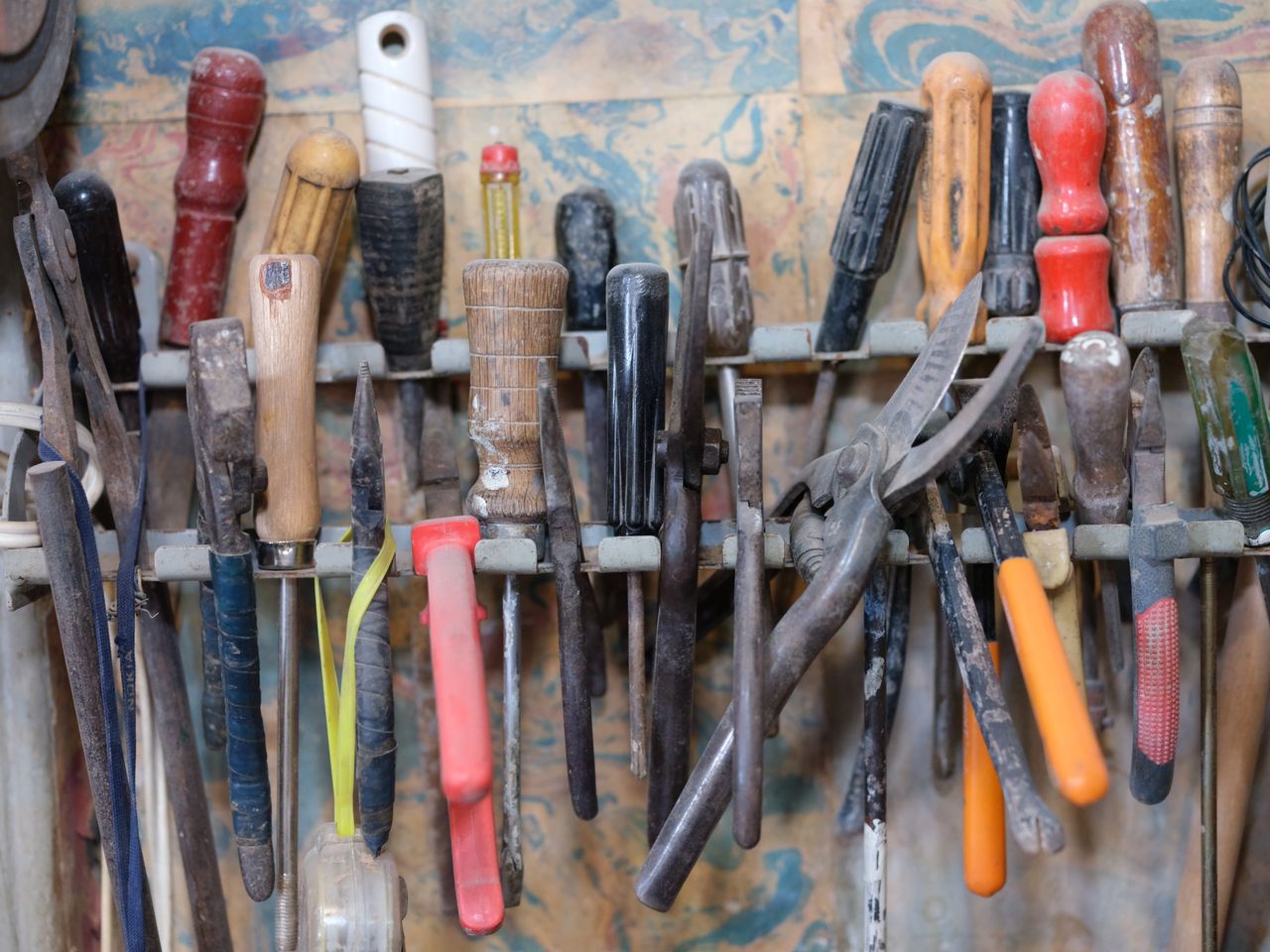 digital-01 A collection of various tools neatly arranged on a workshop rack, showcasing a DIY environment.